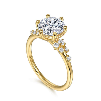 The 14K Y floral band engagement ring by Gabriel & Co features a large prong-set CZ center, smaller diamond accents, and an elegant signature engraving on the side for a timeless look.