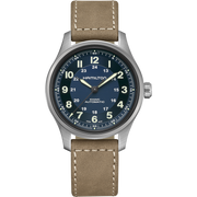 A Hamilton Khaki Field Titanium Automatic watch with a 42mm stainless steel case and a beige leather strap. This military-style timepiece features a dark blue dial with white Arabic numerals, luminous hands, and a date window at the 3 o'clock position. The watch also has a grooved crown.