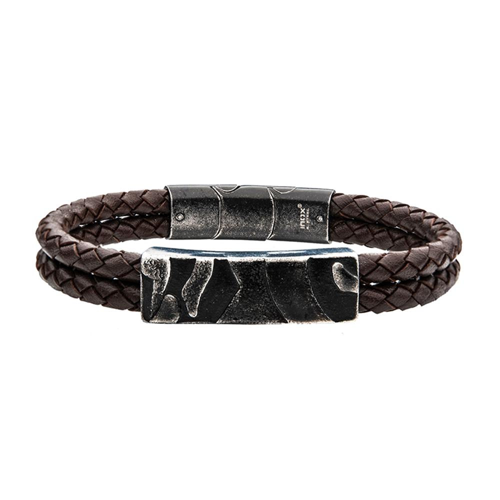 The Men's Brown Leather with Gun Metal Plated 3D Canyon Pattern with Slide by INOX is a double-strand braided brown leather bracelet featuring dark brown bands and a large, gun metal plated magnetic clasp. The clasp boasts a slightly rugged, textured surface with geometric patterns.