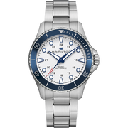 The Hamilton Khaki Navy Scuba Automatic Watch is a silver wristwatch with a metal band that showcases a white dial, silver hands, blue accents, and a date display at the 3 o’clock position. It features a blue ceramic bezel with silver markings and employs an automatic movement ideal for maritime adventures. The brand name is prominently centered on the dial.