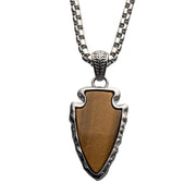 A men’s pendant from INOX, featuring a tiger eye stone set in a brushed steel frame and hanging from a 24-inch chain, showcases earthy browns contrasted with sleek design elements and intricate metalwork.
