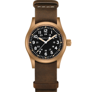 Presenting the Hamilton Khaki Field Mechanical Watch, showcasing a stylish brown leather strap paired with a 38MM bronze case. The black dial is adorned with white numerals and features a 24-hour format in smaller font within the primary 12-hour markings. Luminescent hands and the "Hamilton" brand name positioned below the 12 o'clock mark complete this elegant timepiece.