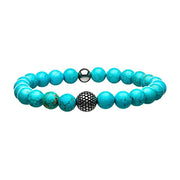 The INOX Men's Blue Turquoise Stone Bracelet features a string of round blue turquoise stone beads with natural veining patterns. It includes one larger steel ornamental bead and a small silver metallic bead, accentuating the overall design. The turquoise beads exhibit variations in color and texture, further enhancing its unique appeal.