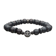 The Men's 10mm Hematite Stone Bracelet by INOX features dark, faceted 10mm hematite stones strung on a gray silicone string. The bracelet is adorned with a small, round metal charm at the center, engraved with a cross and flanked by two smaller metallic beads.