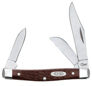 The Brown Synthetic Standard Knife by W.R. Case & Sons Cutlery Co. is a medium stockman pocket knife that features three blades of varying sizes. It has a brown, textured handle adorned with a metal emblem inscribed with "CASE." The blades and bolsters are crafted from shiny metal.