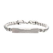 The Matte Steel Chiseled Engravable Drop with Bold Box Chain Bracelet by INOX features a sleek men's box chain design with a chiseled, engravable rectangular plate in the center. The bracelet showcases rounded, smooth chain links and a matte surface with a secure clasp closure.