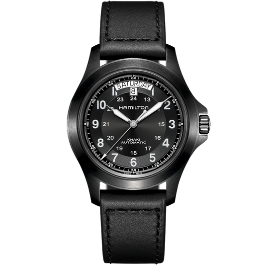 A Hamilton Khaki Field King Automatic Watch with a black leather strap. This timepiece, a tribute to its military heritage, showcases a round black dial with white Arabic numerals for hours and smaller numerals for minutes. Day and date windows are positioned at the top, just below the 12 o'clock marker.