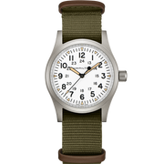 The Khaki Field Mechanical Watch with NATO Strap by Hamilton features a white dial with black numerals displaying both 12-hour and 24-hour time formats. It has a silver case, an olive green nylon strap, and showcases the brand name "Hamilton" on the dial, highlighting its military heritage. The watch hands are black with luminous tips.