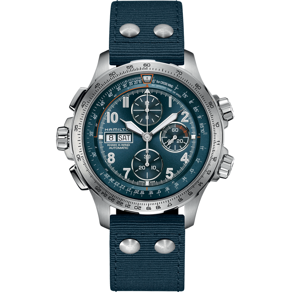 A Hamilton Khaki Aviation X-Wind Automatic Chronograph watch, featuring a silver-toned case and large, detailed face with multiple dials and a date window showing "28" and "SAT." The timepiece includes a blue fabric strap with metallic rivets and a textured band. The background of the image is transparent.