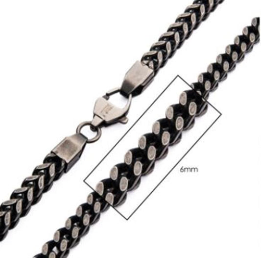 A close-up image of the INOX 6mm Oxidized Steel Franco Chain Necklace, featuring a black and silver 22-inch chain with a lobster clasp. The intricate links are highlighted in a rectangle for detail, showcasing the oxidized steel finish. The clasp and chain design are clearly visible.