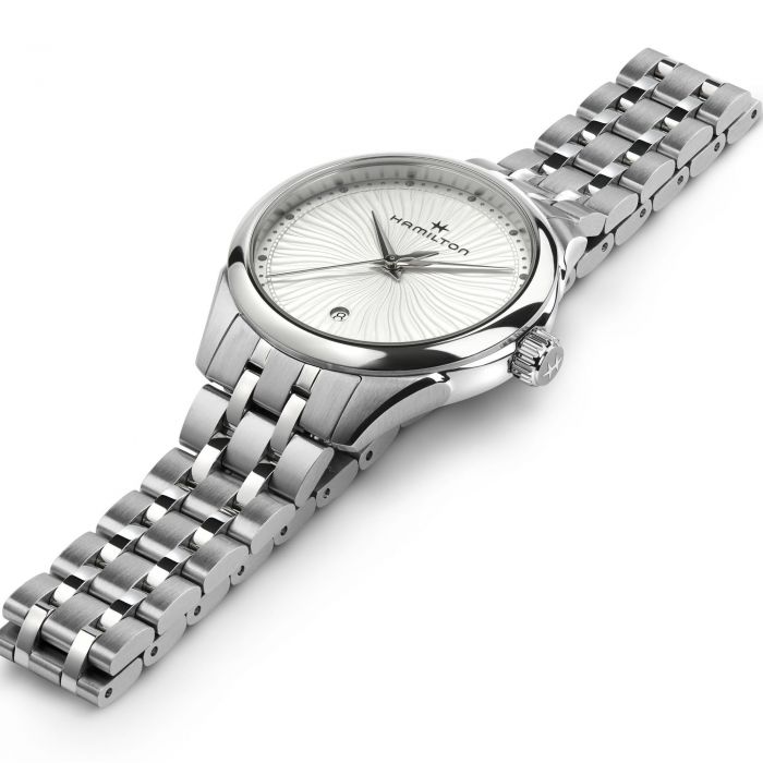 A close-up view of the Lady Quartz Watch by Hamilton showcases its sleek stainless steel bracelet. The round watch face exudes sophisticated charm, featuring silver hands, a date indicator at the 6 o'clock position, and the Hamilton logo below the 12 o'clock marker.