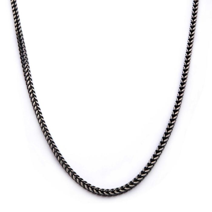 A close-up image of the 4mm Oxidized Steel Franco Chain from INOX, measuring 24 inches. The chain is laid out in a curve, showcasing its intricate design and texture against a plain white background.