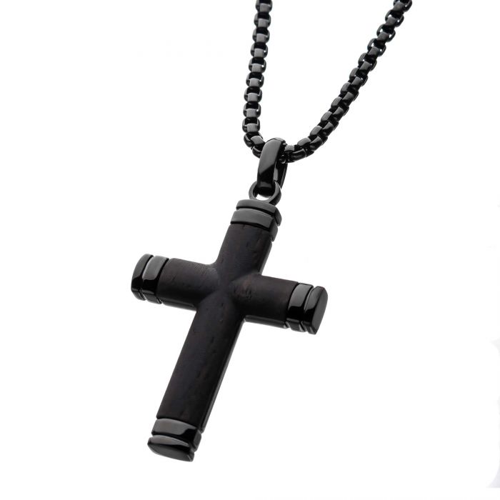 From the INOX collection, the Black Plated Genuine Ebony Wood Inlayed Cross Pendant with Black Bold Box Chain features a sleek black cross with a glossy ebony wood inlay. The men's pendant showcases cylindrical arms capped with shiny ends, all suspended from a textured black box chain composed of small, rectangular links against a plain white background.