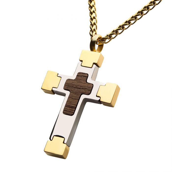 The 18K Gold Plated Cross Pendant with Walnut Wood Inlay by INOX showcases a two-toned cross design enhanced by a distinct walnut wood inlay. The pendant, crafted from shiny metal with gold edges and corners, is elegantly highlighted by the wooden cross detail at its center. Accompanied by a 24" long 18K gold plated wheat chain, this piece boasts both a refined and stylish appearance.